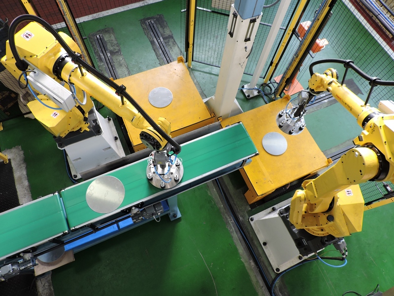 Robots con manos circulares con ventosas manipulando grandes formatos circulares Robots con manos circulares con ventosas manipulando grandes formatos circulares